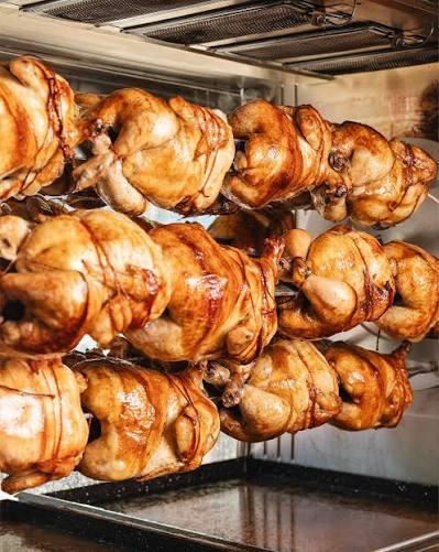 Pollos girando en el spiedo sobre las llamas